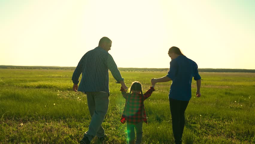 Dad mother child play together on sunset. Child daughter family playing in park. Family dad kid mom. Happy family dad mom child run walk in meadow, kid holding parents hands on sun day. Childhood Royalty-Free Stock Footage #3446718623