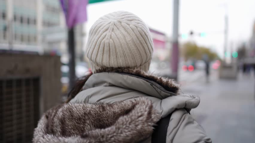 Slow-motion video of a young Filipino woman in her 20s walking in Seoul, South Korea on a cold winter day