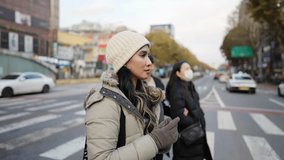 Slow-motion video of a young Filipino woman in her 20s walking in Seoul, South Korea on a cold winter day