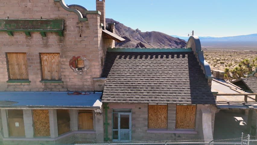 Aerial-Truck left-Abandoned boarded up train depot-Ryolite, Nevada. Once serviced by three railroads the rail service ended in 1919.  The structure was used briefly as the Ryolite Ghost Casino.
