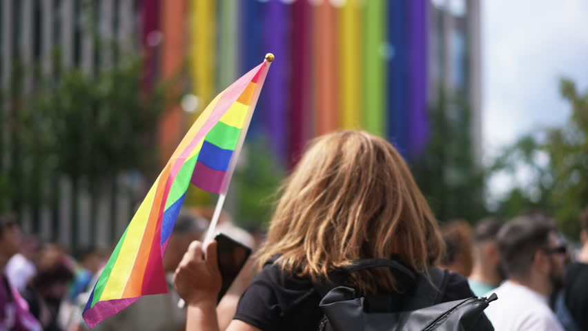 Many lesbian people wave rainbow flag. Crowd walk city street. Fun lgbt community symbol. Stop no homophobia concept. Pride fest. Bi gay woman go csd love day. Queer culture parade. Hold colorful flag