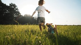 Happy baby girl with dog in park. child with pet run through grass in meadow at sunset. Happy girl with dog run and play in park on grass.Freedom in nature in summer.Dog pet plays with child in nature - Powered by Shutterstock - Get 15% off with code: PIKWIZARD15