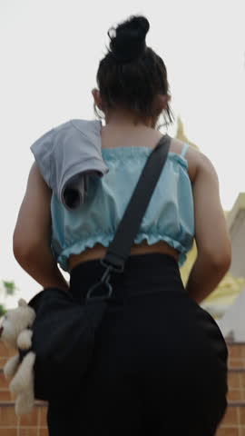 Thai girl approaching a golden religious statue
