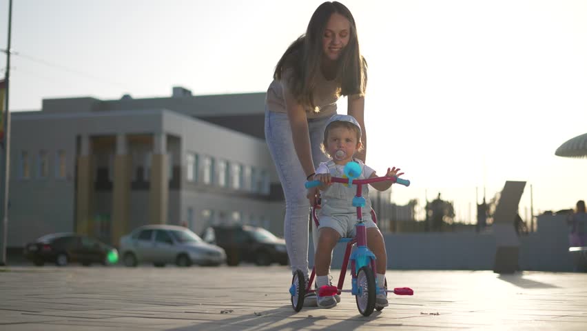 Family day.happy child learns to ride bike with his mother.family day outdoors.mom and child on bike on family day.weekend together fresh air.happy child on bicycle.child's dream.happy family concept Royalty-Free Stock Footage #3446915985