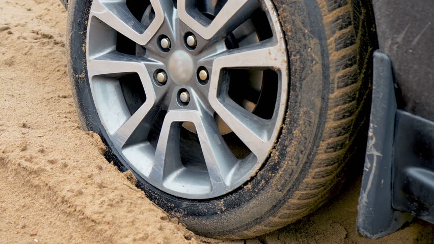 Tires skids on sandy road close up. Car in sand . SUV vehicle was stuck on dirty off road. SUV vehicle struggling to gain traction in sand, off road in desert Royalty-Free Stock Footage #3446986511