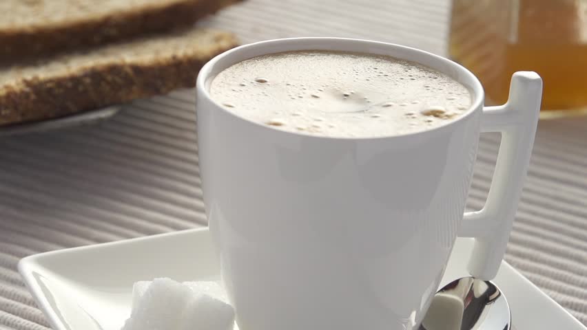 Slowmotion milk drops splash in coffee tilt up