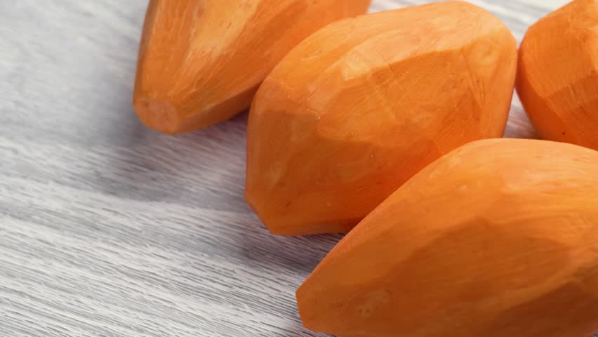Peeled sweet potatoes on a board. Fresh vegetable root. Rotation