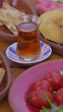 Vertical video. Delight in the vibrant tapestry of a traditional Turkish breakfast with this closeup stock video. From fresh vegetables to creamy cheese, warm bread, and local-style scrambled eggs