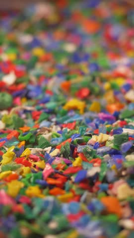 small plastic fragments close up, vertical video. plastic waste, plastic pollution, environment. microplastics, plastic recycling concept