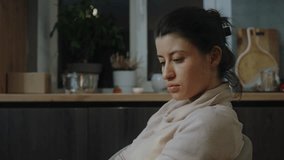 Unhappy lonely woman looking at camera, wanting call smartphone to inform decision sitting in the kitchen. - Powered by Shutterstock - Get 15% off with code: PIKWIZARD15