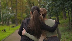 Back view two Caucasian girls active sportswomen happy ladies female friends walking together in park outdoors backside women laughing after sport training in city give high five good friendship hug - Powered by Shutterstock - Get 15% off with code: PIKWIZARD15