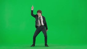 Portrait of male model in suit on chroma key green screen. Handsome young businessman in trendy suit dancing funny disco dance at the camera. - Powered by Shutterstock - Get 15% off with code: PIKWIZARD15