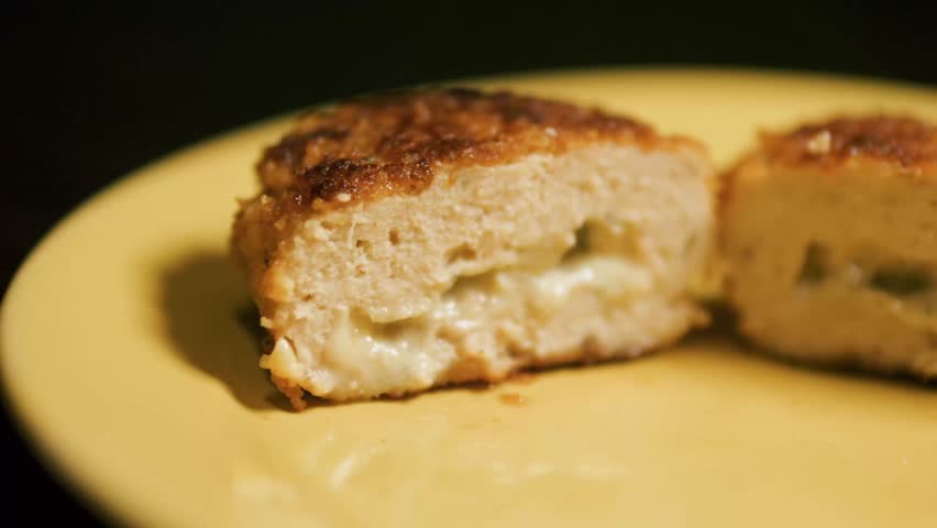 Pressing chicken Cordon Bleu cutlet with cheese inside with a fork. Royalty-Free Stock Footage #3447264181