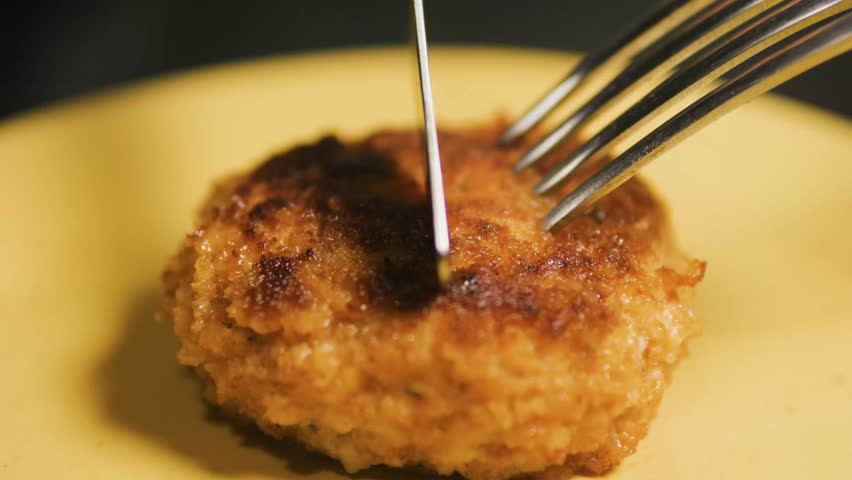 Cutting chicken Cordon Bleu cutlet with cheese inside with knife and fork. Royalty-Free Stock Footage #3447268417