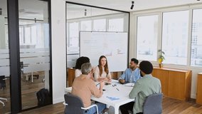 A team engages in an animated discussion, a mature man with glasses gestures passionately, emphasizing a point, while his colleagues listen intently, illustrating an interactive brainstorming session - Powered by Shutterstock - Get 15% off with code: PIKWIZARD15