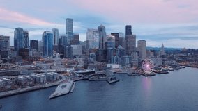 Financial and residential buildings cityscape view on overcast day 4K. Seattle Washington USA aerial drone footage of Waterfront park with Great Wheel. Downtown skyscrapers on cinematic background