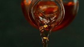 Super Slow Motion of Pouring Whisky from Bottle into Glass. Filmed on High Speed Cinema Camera, 1000 fps, Placed on High Speed Cine Bot. Camera Follows the Stream of Liquid. - Powered by Shutterstock - Get 15% off with code: PIKWIZARD15