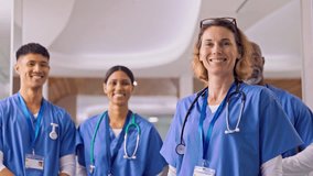 Portrait of smiling multi cultural medical team wearing scrubs in modern hospital corridor - shot in slow motion - Powered by Shutterstock - Get 15% off with code: PIKWIZARD15