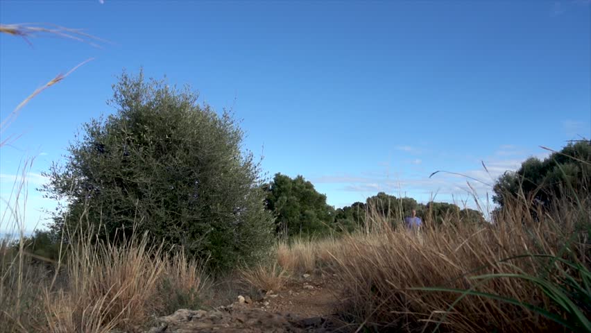 Slow motion, overweight man running on mountains.