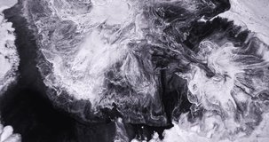 4k footage of black white paints exploding abstract background, close up. White ink spread, dynamic mix in black liquid. Detailed splash of dark monochrome paint in motion, close-up. Watercolor liquid