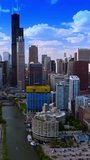 Construction site nearby underground railways in Chicago. Drone footage over Chicago River approaching skyscrapers. Vertical video.