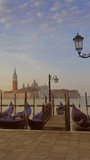 Traditional Gondolas on Canal Grande with San Giorgio Maggiore church in the background at morning, San Marco, Venice, Italy. Vertical video