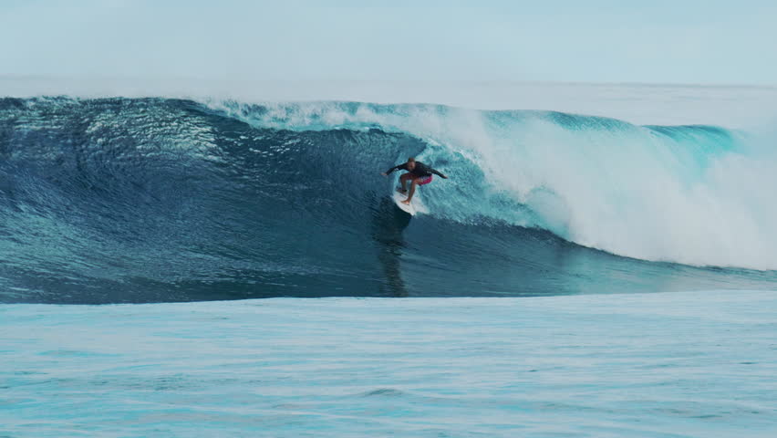 Surfer rides the big ocean wave in the Maldives