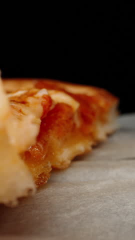 Pizza in a box on the table. Dolly slider extreme close-up.  Vertical video.