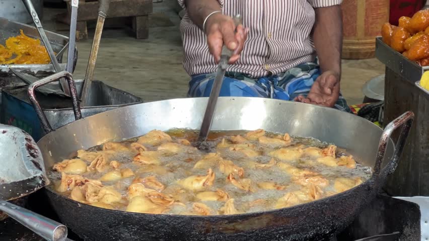 Close up of a man preparing hot samosa in a roadside hotel in Kolkata, India. No face.