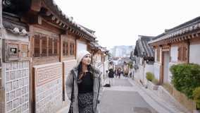 Slow-motion video of a young Filipino woman in her 20s taking a walk in Hanok Village, North Village, Seoul, Republic of Korea on a cold winter day