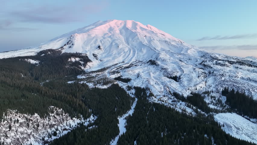 Dawn illuminates Mount St. Helens, not far from both Seattle and Portland, as it rises from the forested landscape in Washington. This active and scenic stratovolcano last erupted on May 18, 1980.