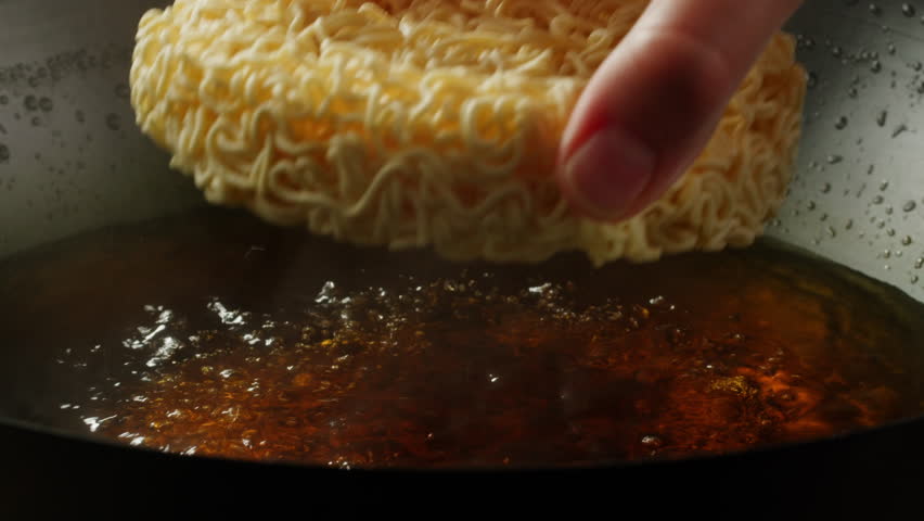 Cooking instant noodles in boiling water with spices close-up. Asian fast food. Instant noodles, or instant ramen, is a type of food consisting of noodles sold in a precooked and dried block with Royalty-Free Stock Footage #3447511961