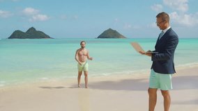 Two young male people on the stunning beach of the Hawaii island, one man working remotely on laptop and another gentleman with bare torso having fun. High quality 4k footage