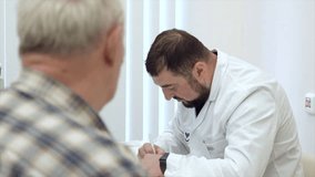 Senior male patient talking with man doctor in the office. Clip. Writing prescription to senior patient. - Powered by Shutterstock - Get 15% off with code: PIKWIZARD15