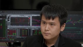 Chinese Businessman Talking On The Phone With Stock Market On Computer Monitors In Background. closeup shot - Powered by Shutterstock - Get 15% off with code: PIKWIZARD15