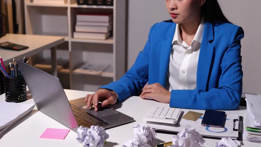 A charming Asian woman with a smile wearing a blue suit stands with her arms crossed confidently working at a start-up business within a company. Royalty-Free Stock Footage #3447621727
