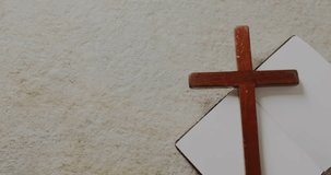Animation of easter sunday text over christian cross and book on grey background. Easter, religion, christianity, tradition and celebration concept digitally generated video.