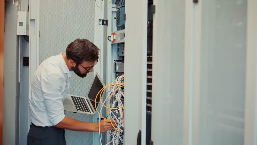 System Engineer Control Room IT Administrator. Server Engineer Work On Laptop in Data Center. Male Server IT Engineer Work Data Center. Man Work In Server Room. Male Typing On Laptop In Server Room Royalty-Free Stock Footage #3447636047