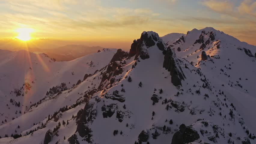 Golden sunset over Tigaile Mari peak in Ciucas Mountains, snowy landscape