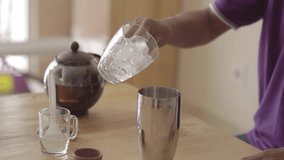 closeup of person pouring ice cubes into a pitcher