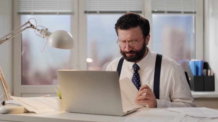 Tired, overworked businessman worker is anxiously trying to find required document. Puzzled office worker tired of bureaucracy and paperwork Royalty-Free Stock Footage #3447693121
