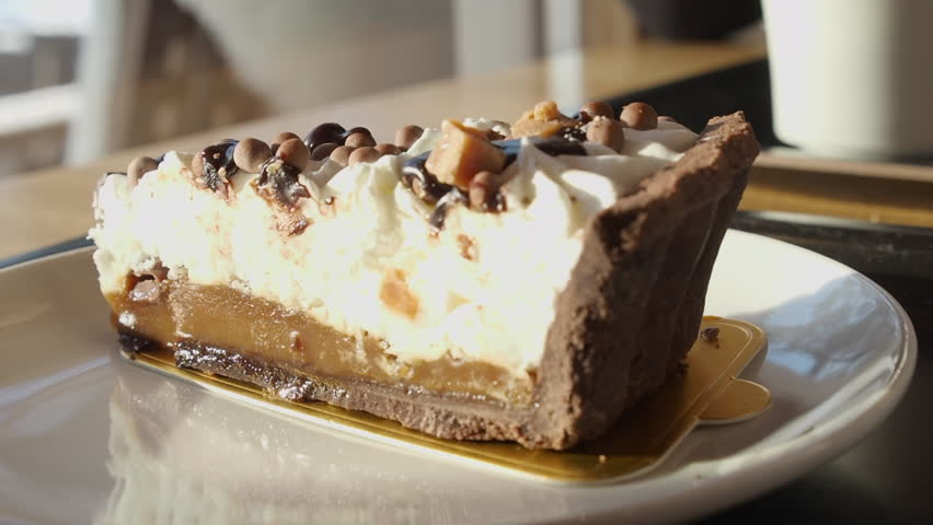 Delicious sweet dessert in cafe is sliced into with fork, close-up