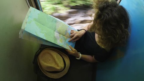 Woman Tourist Traveling By Train Reading Map. 4K. 