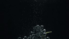 Close-up of a sprig of grapes falling into the water against a black background. Slow motion - Powered by Shutterstock - Get 15% off with code: PIKWIZARD15