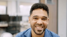Hispanic man smiling at camera working in a coworking