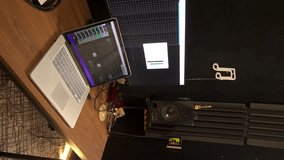 Vertical video of camera flying around recording studio with room for microphone and place of sound engineer recording sound and voice. Computer and microphone for audio and voice mixing.