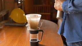man's hand  pour ground coffee over paper filter in clever coffee dripper before pouring water from drip kettle. Process of brewing pour over filter clever coffee dripper.4k video