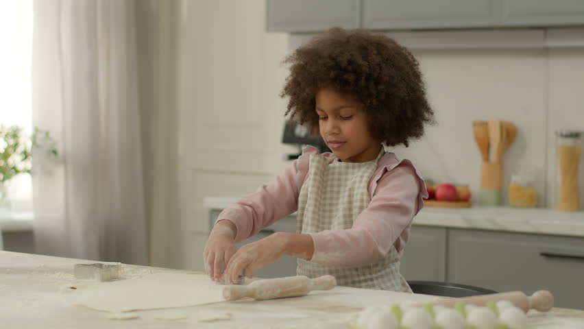 Little African American girl wear apron child kid ethnic daughter development learning to cook baking cooking alone in kitchen home prepare flour dough pie cookies homemade delicious breakfast receipt Royalty-Free Stock Footage #3447937621