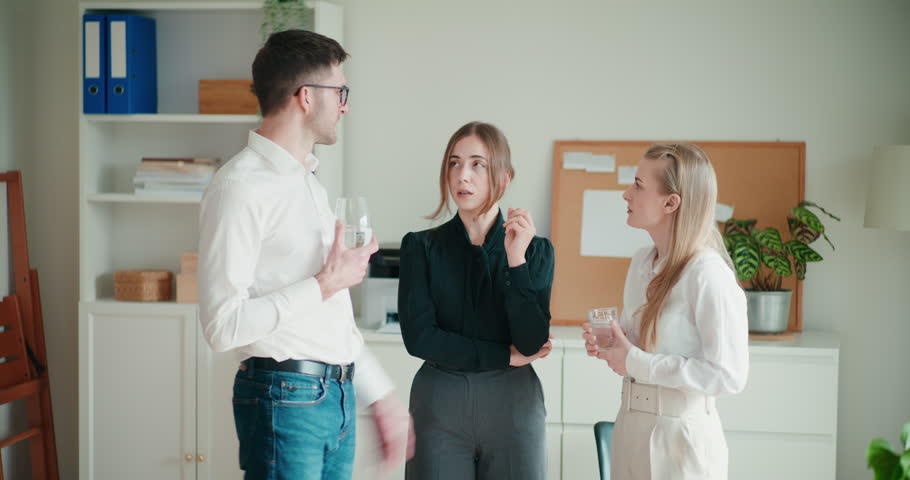 Young businessman with businesswomen discussing strategy while standing together at corporate workspace