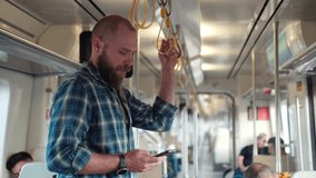 Young adult playing video games or watching social media content while heading to work office in public transport, subway, suburb commuter train. Technology in daily life addiction to digital gadget - Powered by Shutterstock - Get 15% off with code: PIKWIZARD15